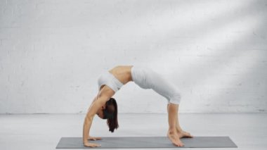 urdhva dhanurasana ve eka pada urdhva dhanurasana uygulayan kadının yan görünümü