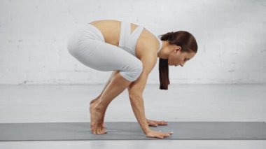 yalınayak kadın salamba sirsasana pratik ve yoga mat oturan yan görünümü