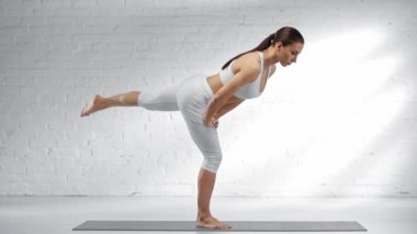 yalınayak kadın virabhadrasana pratik ve yoga mat üzerinde dengeleme