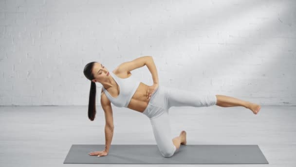 Femme Levant Jambe Pratiquant Kapinjalasana Assis Sur Tapis Yoga — Video
