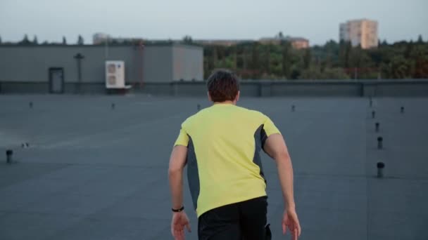 运动员穿着运动服在屋顶和楼梯上奔跑的后视图 — 图库视频影像