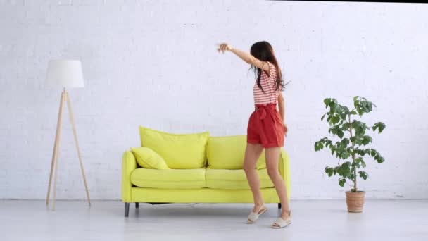 Χαρούμενη Νεαρή Γυναίκα Που Χορεύει Ευρύχωρο Σαλόνι Στο Σπίτι — Αρχείο Βίντεο