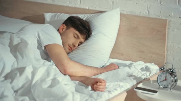 Άντρας Λευκό Μπλουζάκι Κοιμάται Στο Κρεβάτι Ξυπνάει Κρατά Smartphone Και — Αρχείο Βίντεο