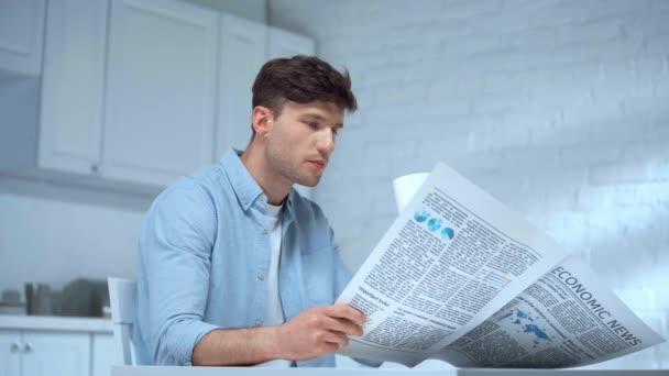 Hombre Enfocado Camiseta Azul Beber Café Leer Periódico Mañana Cocina — Vídeos de Stock