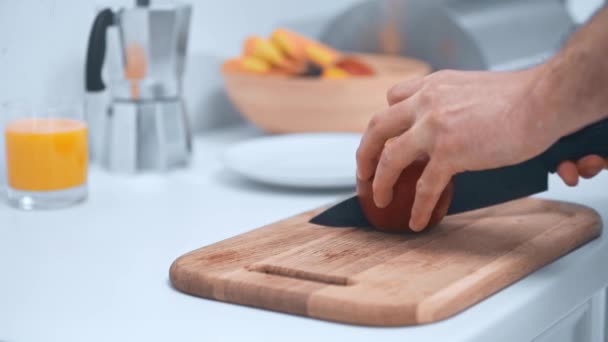 木製のまな板にリンゴを切り 台所でソーサーにスライスを置く男の部分的なビュー — ストック動画