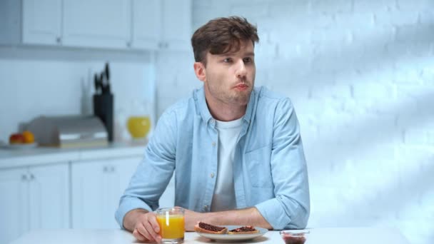 Hombre Comiendo Pan Tostado Con Mermelada Bebiendo Jugo Naranja Mirando — Vídeos de Stock