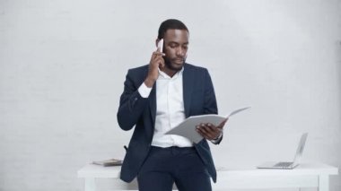 işyerinde dururken akıllı telefon üzerinde konuşurken ciddi afro-amerikan işadamı