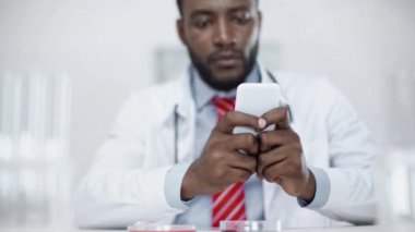 klinik laboratuvarda akıllı telefon kullanarak Afrikalı Amerikalı bilim adamı seçici odak