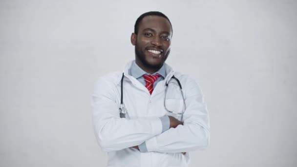 明るいアフリカ系アメリカ人の医師は 腕を組んで立って Okサインを示し カメラで微笑んでいます — ストック動画