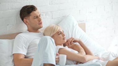 güzel çift gülümseyerek, sarılma ve yatakta konuşurken, adam kahve içme