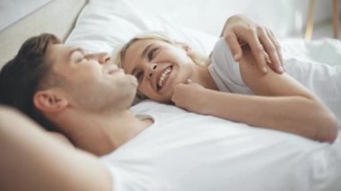 adam konuşma ve yatakta güzel gülen ve gülümseyen kadın kucaklayan