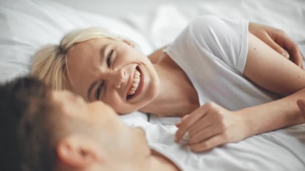 美丽的女人说话 手势和笑 男朋友拥抱和触摸在床上的女朋友的鼻子 — 图库视频影像