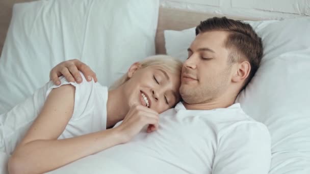 美丽的女人说话和拥抱微笑的男人在床上 — 图库视频影像
