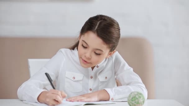 Sonriente Linda Preadolescente Colegiala Haciendo Tarea Escribir Libro Copia Escritorio — Vídeos de Stock