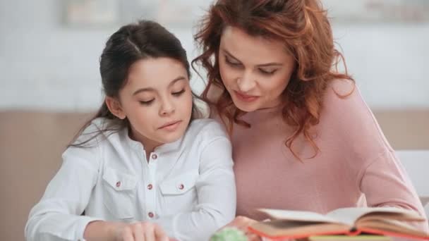 微笑的母亲和女儿一起在家做作业 — 图库视频影像