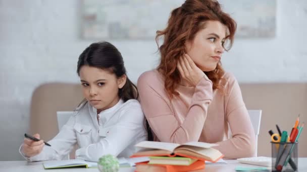 不高兴的母亲和女儿坐在书桌前 看着远方 而一起做作业 — 图库视频影像