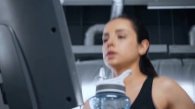 spor salonunda koşu bandı üzerinde çalışan güzel genç sporcu düşük açı görünümü