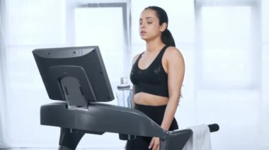 güzel sporcu treadmill üzerinde yürüyüş, spor salonunda kamera ve içme suyu bakıyor