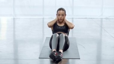 güzel genç sporcu spor merkezinde fitness mat oturmak up yapıyor