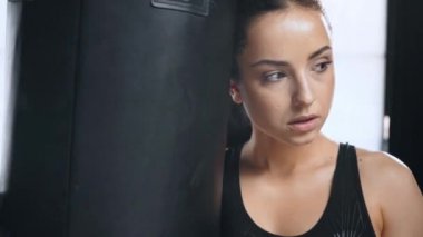 spor salonunda kamera bakarak delme çantası yakın boks eldiven güzel yorgun sporcu