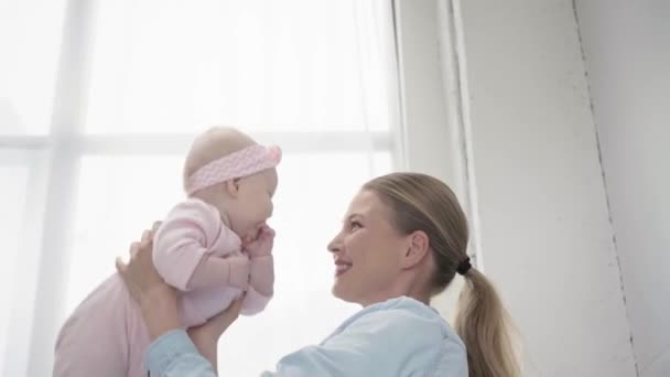 乳幼児の腕に抱かれた母親の低角度図 — ストック動画