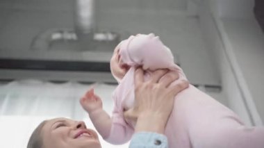 kollarında neşeli bebek tutan anne düşük açı görünümü 