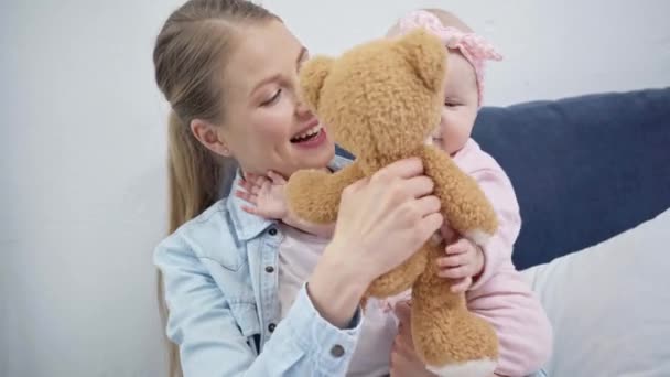 Madre Sosteniendo Oso Peluche Cerca Hija Bebé — Vídeos de Stock