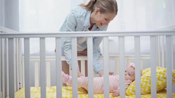 快乐的母亲把婴儿放在婴儿床 — 图库视频影像