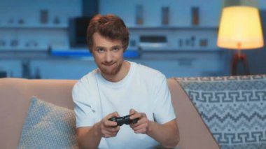 Kiev, Ukrayna - 12 Mart 2019: video oyunu oynayan ve oturma odasında evet jesti gösteren adam
