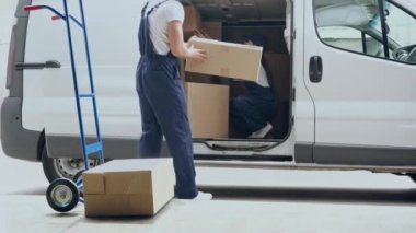 teslimatçı el kamyonundan kutu alıp arabada teslimatçı kadına vermek 