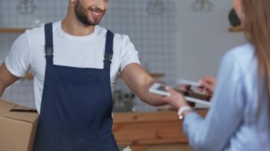 teslimat alan ve dijital tablete imza atan kadının kırpılmış görünümü