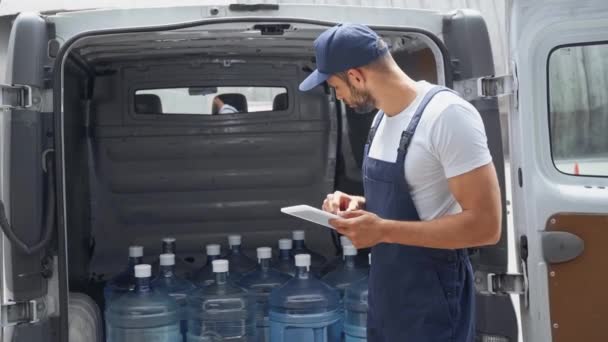 Homem Entrega Água Usando Tablet Digital Contando Garrafas Carro — Vídeo de Stock