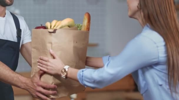 自宅で食料品の配達を受け取る笑顔の女性のトリミングされたビュー — ストック動画
