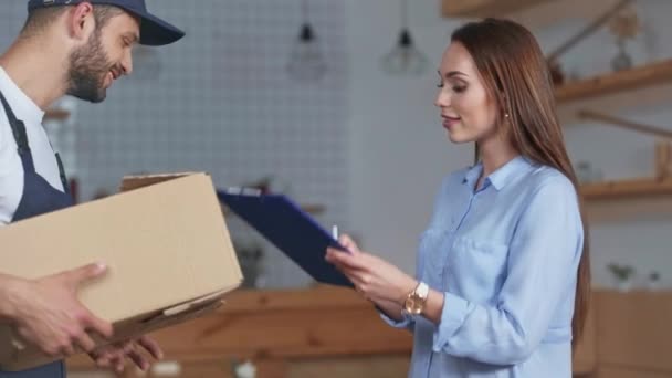 自宅で配達人から小包を受け取る笑顔の女性 — ストック動画