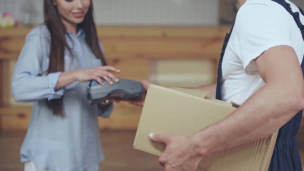 Vrouw Ontvangen Pakket Van Delivery Man Zetten Handtekening Creditcard Reader — Stockvideo