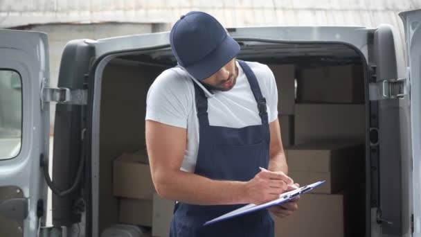 Delivery Man Writing Clipboard Talking Smartphone Car Parcels — Stock Video