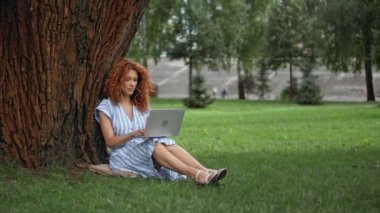 mutlu kızıl saçlı kız müzik dinleme ve dizüstü bilgisayar kullanarak 