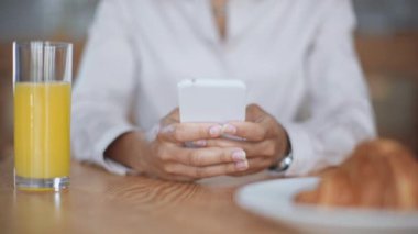 kafede akıllı telefon kullanarak Afrikalı Amerikalı iş kadını kırpılmış görünümü