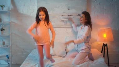 anne ve kızı geceleri yatakta dans