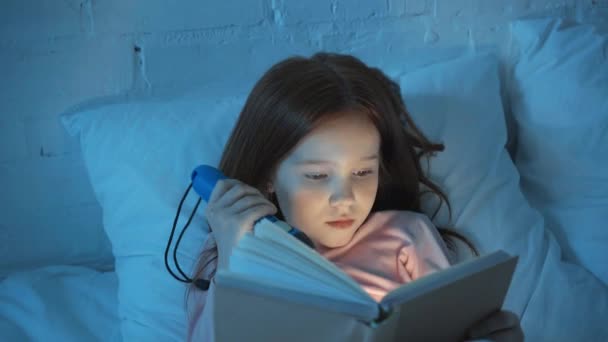 Emotional Child Reading Book Flashlight Bed Night — Stock Video