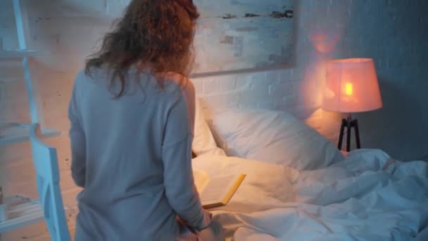 Anya Olvasni Könyvet Miközben Lánya Alszik Éjjel Ágyban — Stock videók