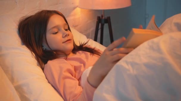 Niño Acostado Cama Leyendo Libro Por Noche — Vídeos de Stock