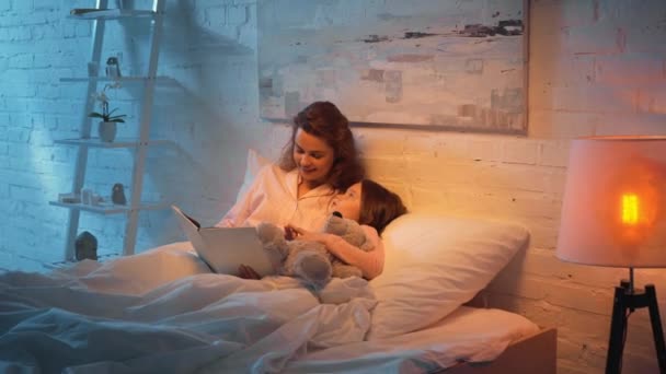 Madre Leyendo Libro Hija Con Osito Peluche Cama — Vídeos de Stock