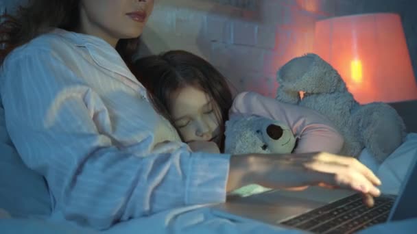 Madre Usando Laptop Mientras Hija Durmiendo Con Osito Peluche — Vídeos de Stock