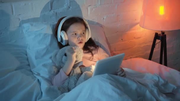 Bambini Che Ascoltano Musica Cuffia Ballano Usano Tablet Digitali Letto — Video Stock