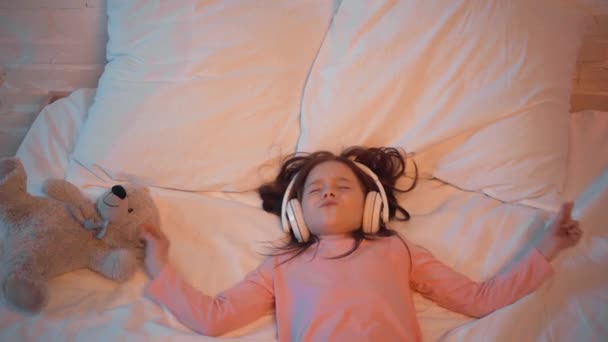 Bambino Che Ascolta Musica Cuffia Mentre Sdraiato Letto — Video Stock