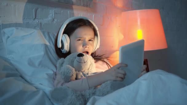 Niño Escuchando Música Auriculares Cantando Usando Tableta Digital Cama — Vídeos de Stock