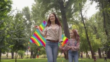 mutlu anne ve kızı parkta uçurtma ile yürüyüş