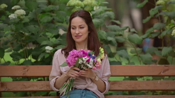 Donna Sognante Con Bouquet Seduta Panchina Nel Parco — Video Stock