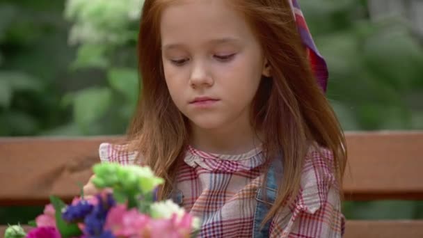 Очаровательный Вдумчивый Улыбающийся Ребенок Цветами Парке — стоковое видео